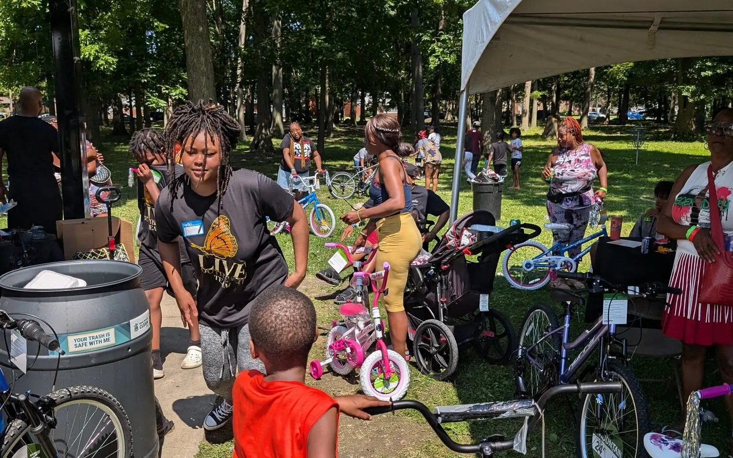 Volunteers and children at an outdoor L.I.V.E. Outreach community event with bicycles